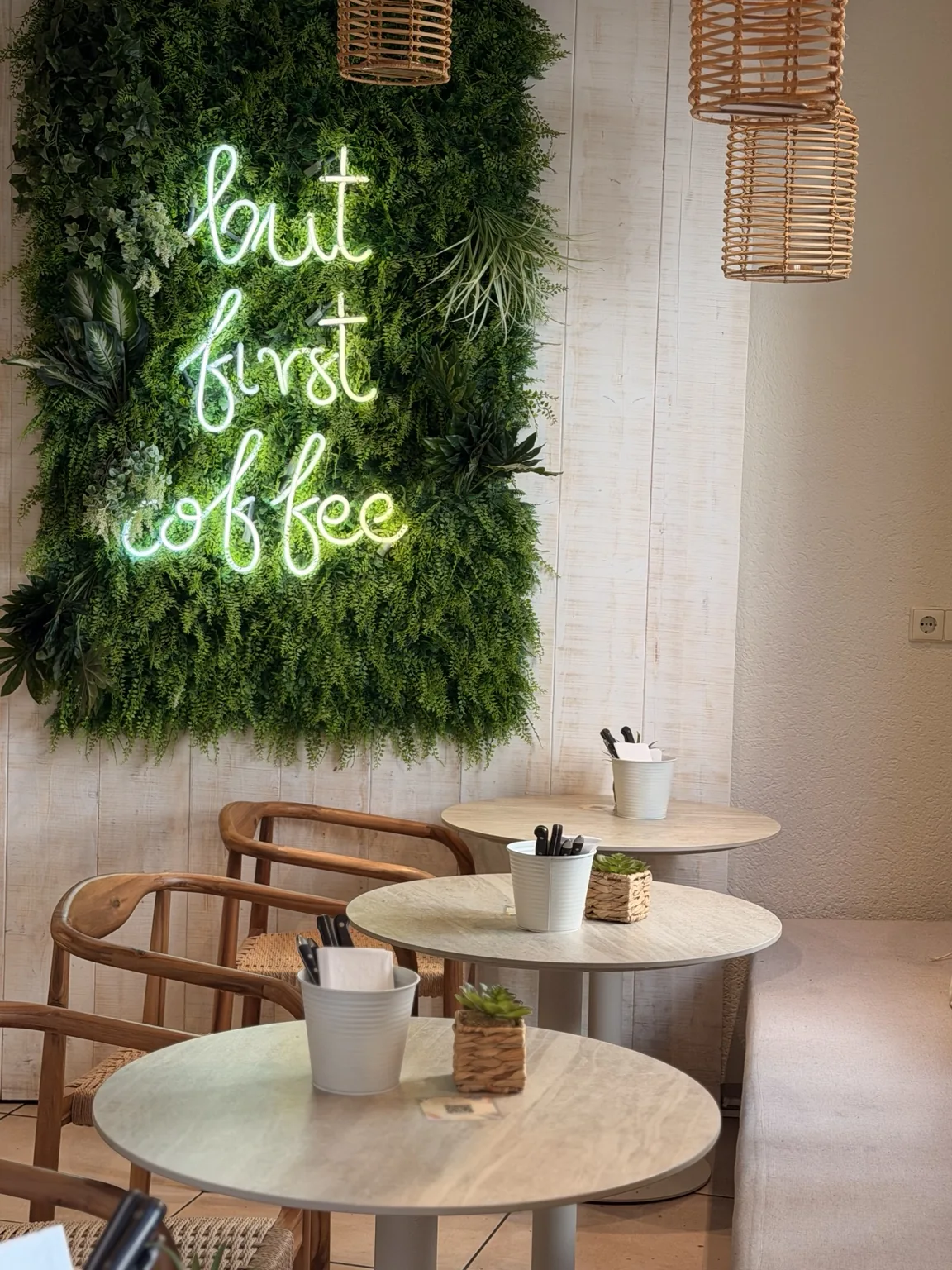 Sitzbereich im Bloggers Konstanz mit Pflanzenwand und Leuchtschrift